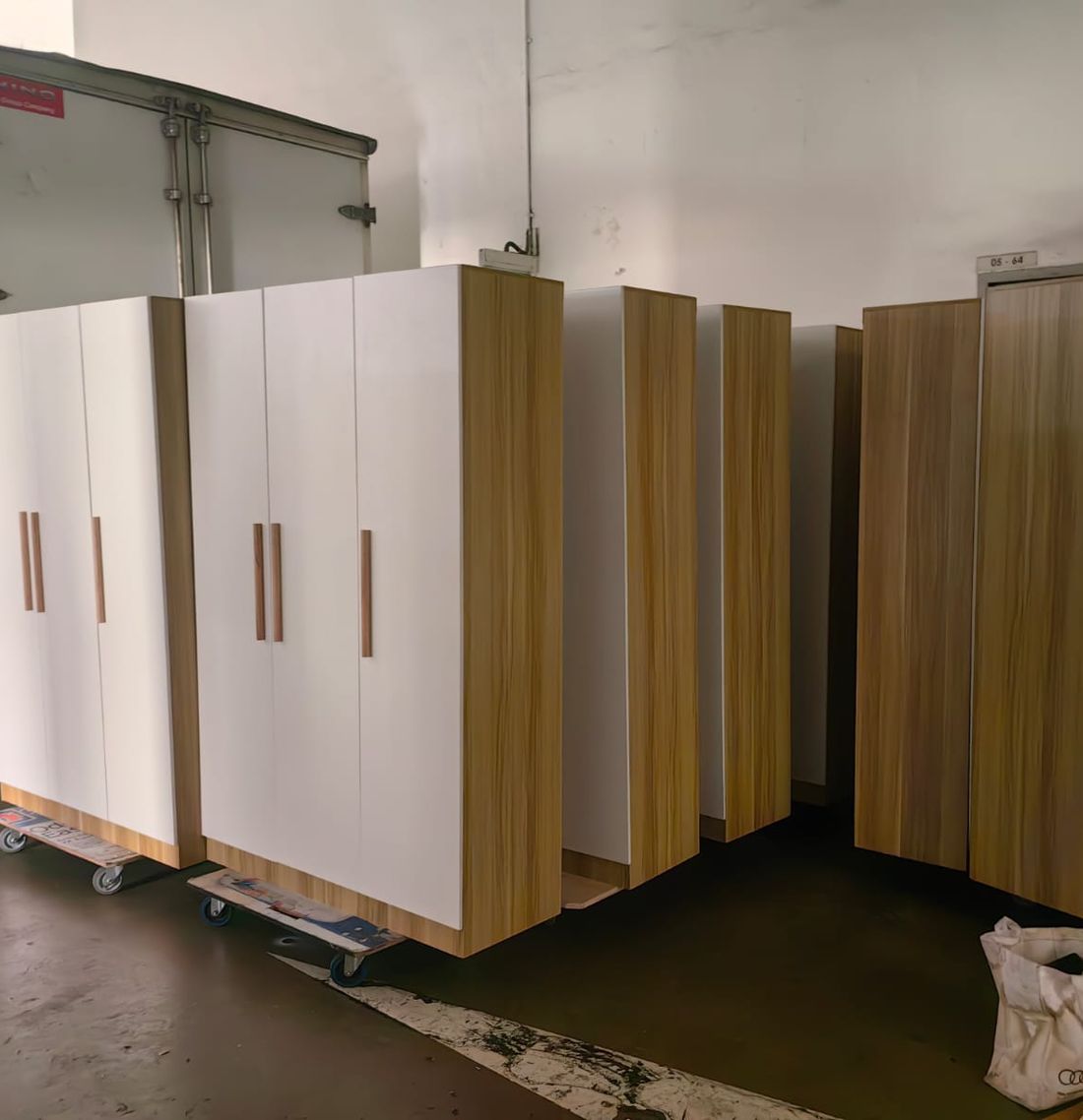 White and wood-finish wardrobes laid out for assembly