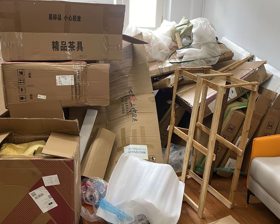 Old cartons and furniture piled up inside a home, waiting to be cleared