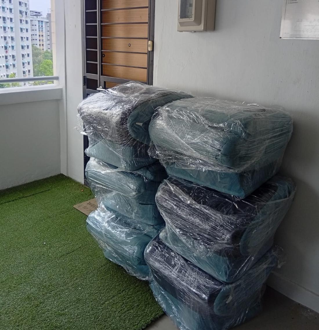 Wrapped sofas stacked neatly beside a front door