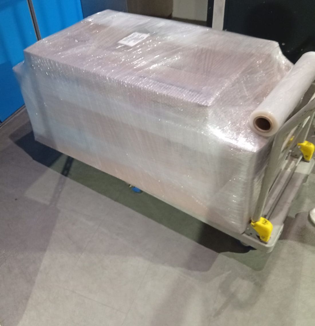 A large piece of furniture wrapped in protective film