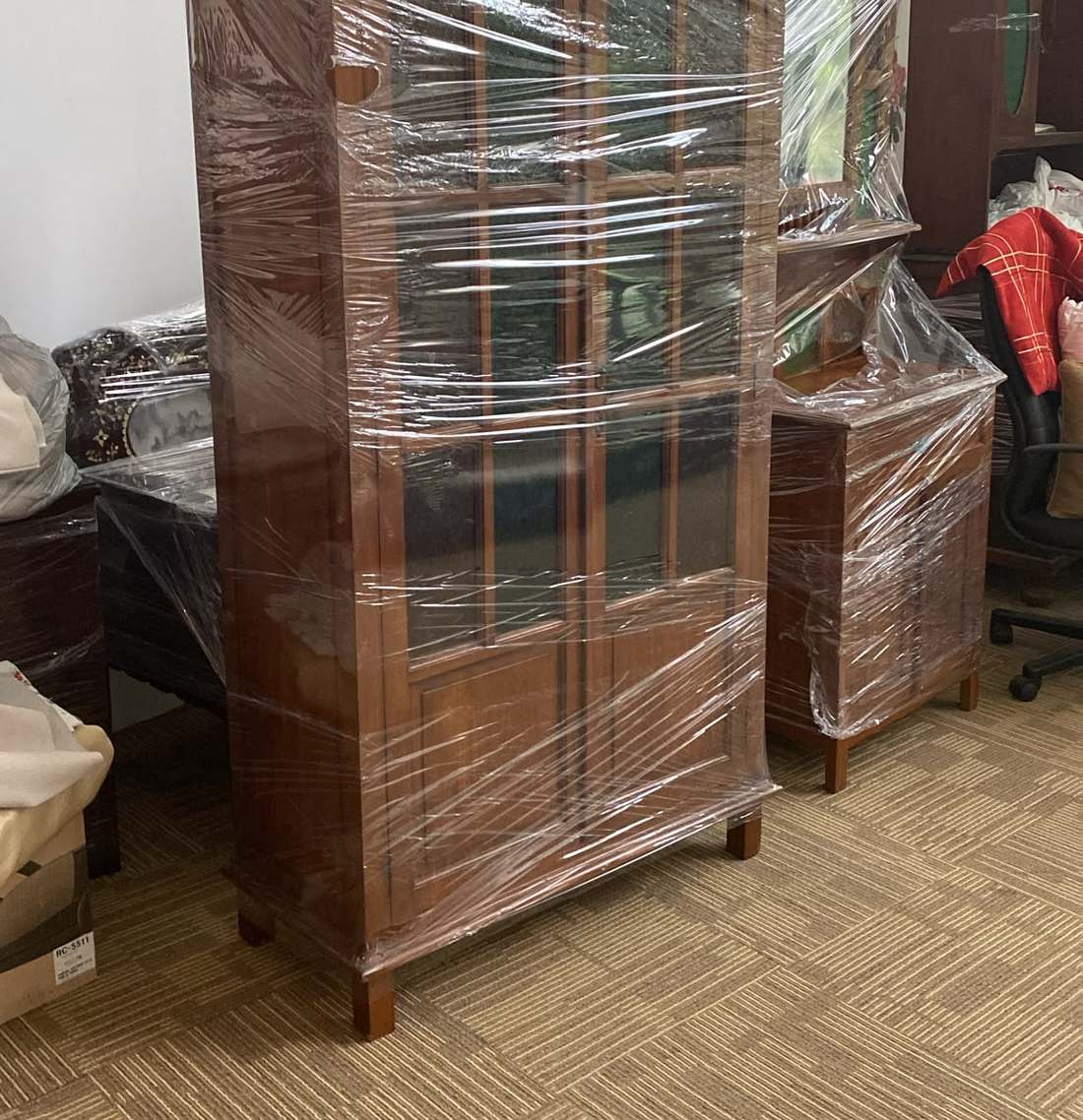 A wooden glass-door cabinet wrapped for delivery